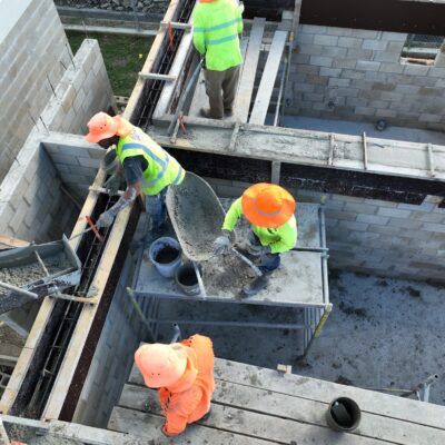 Construction workers completing reinforced concrete and formwork installation on an active structural building project.