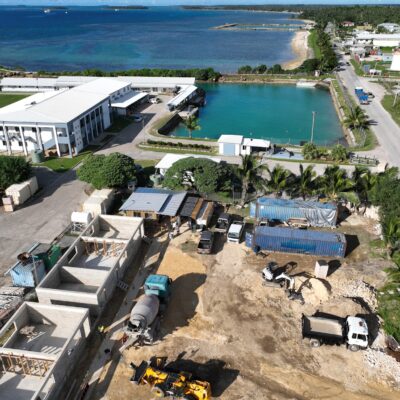 Aerial drone view of a coastal commercial construction project by Build N Concrete Ltd featuring active building works and waterfront surroundings.