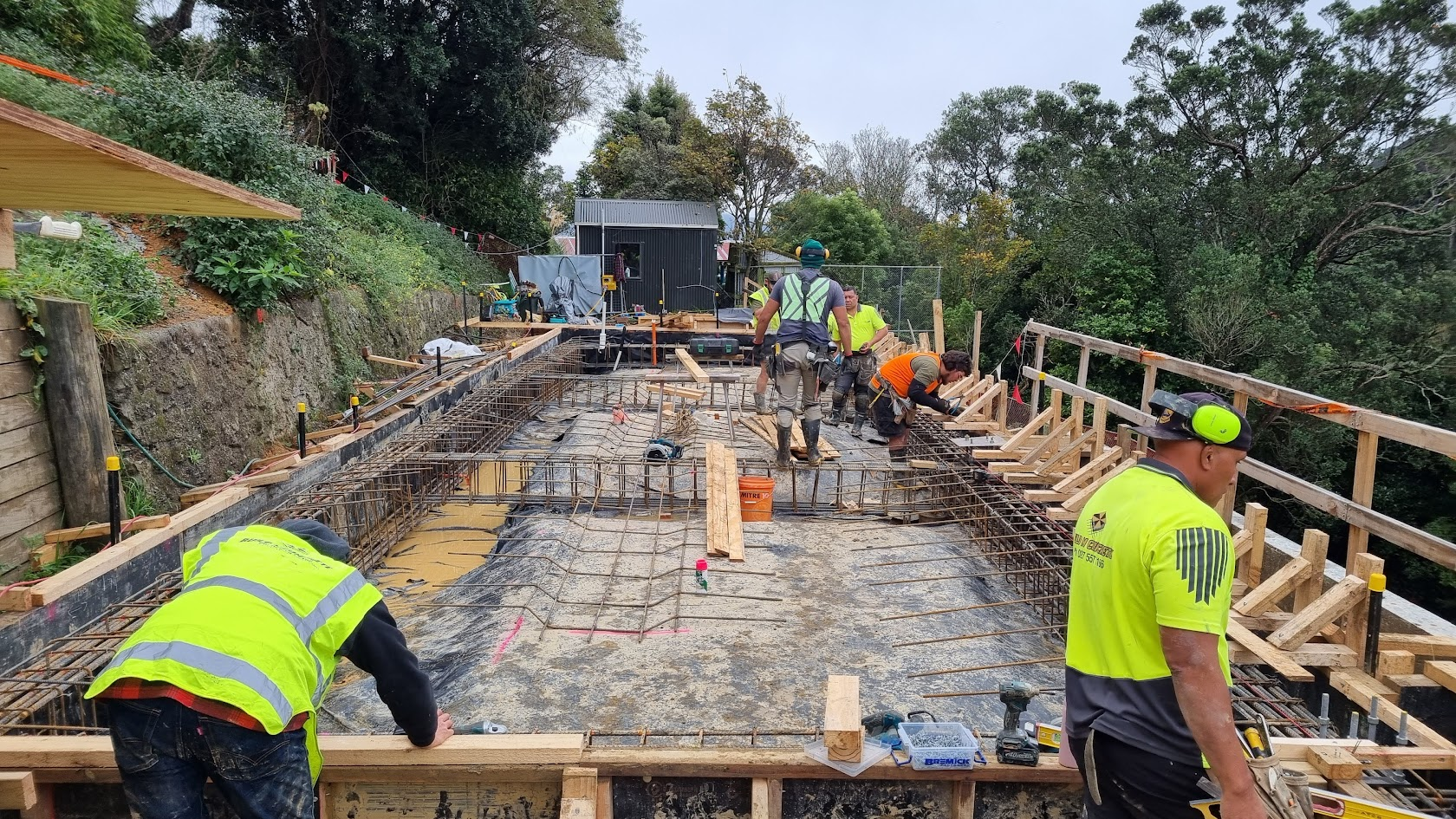 Construction team preparing concrete formwork and structural foundations on-site for a residential build.